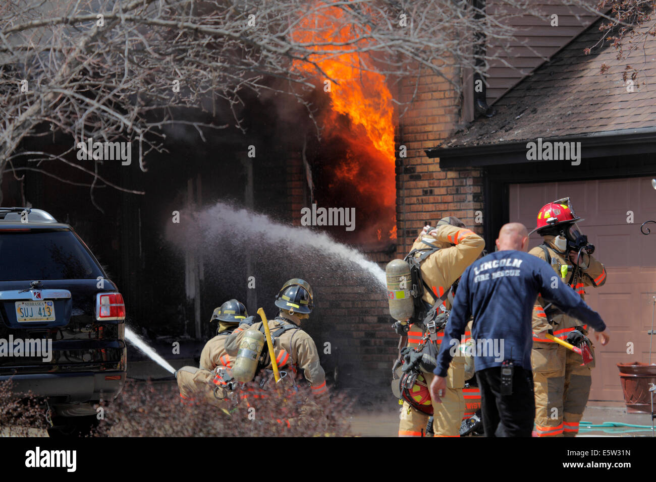 Feuerwehr am Unfallort ein Haus in Brand. Stockfoto