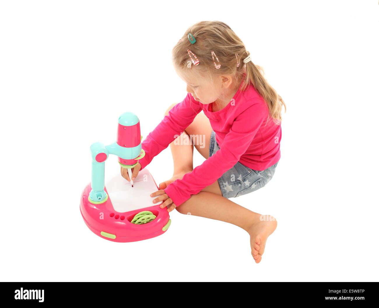 Kleines Mädchen mit einem Spielzeug-Projektor Bild zeichnen Stockfoto