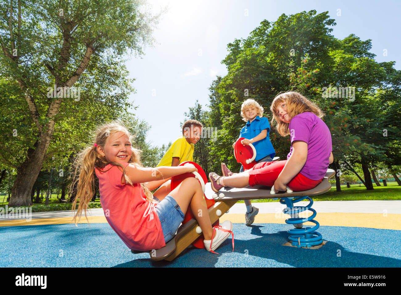 Kinder sitzen auf Spielplatz-Karussell mit Federn Stockfoto