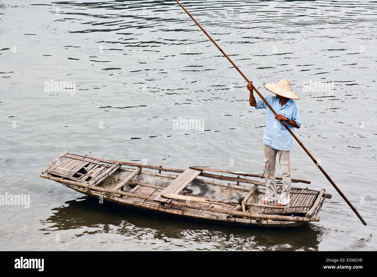 Oarsman, der den Fluss auf einem speziell angefertigten Bambusfloß in Nordvietnam runterbohrt. Traditionelles Verkehrsmittel auf Flüssen und Seen. Ländliche Szene und Leben Stockfoto