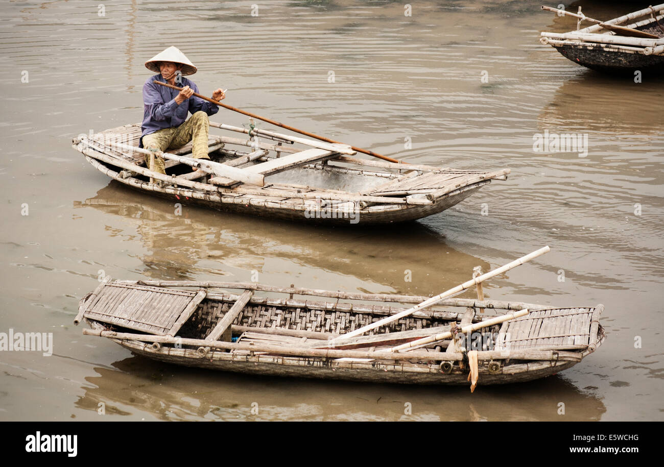 Traditionelle vietnamesische Boote mit Ruderer in Vietnam. Bambus Zeile Boote schwimmend auf dem Fluss. ländliche Szene mit traditionellen vietnamesischen Lebensstil Stockfoto