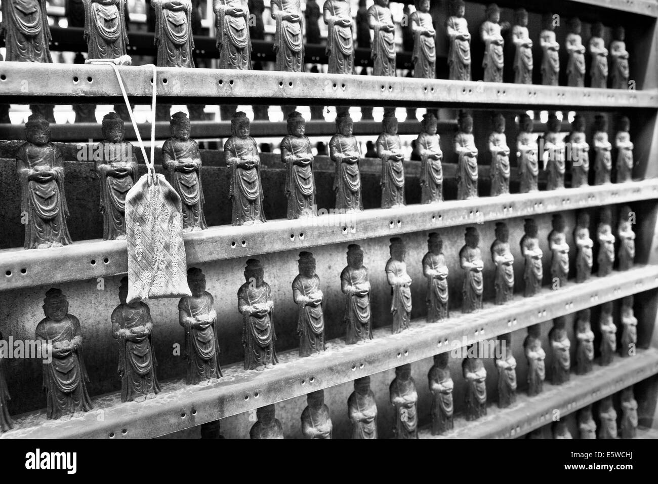 Reihen von Mini Buddha Figuren Linie das innere Heiligtum des Shintō-buddhistischen Tempel in Nagano City, Japan, schwarz-weiß-Bild der religiösen Objekte Stockfoto