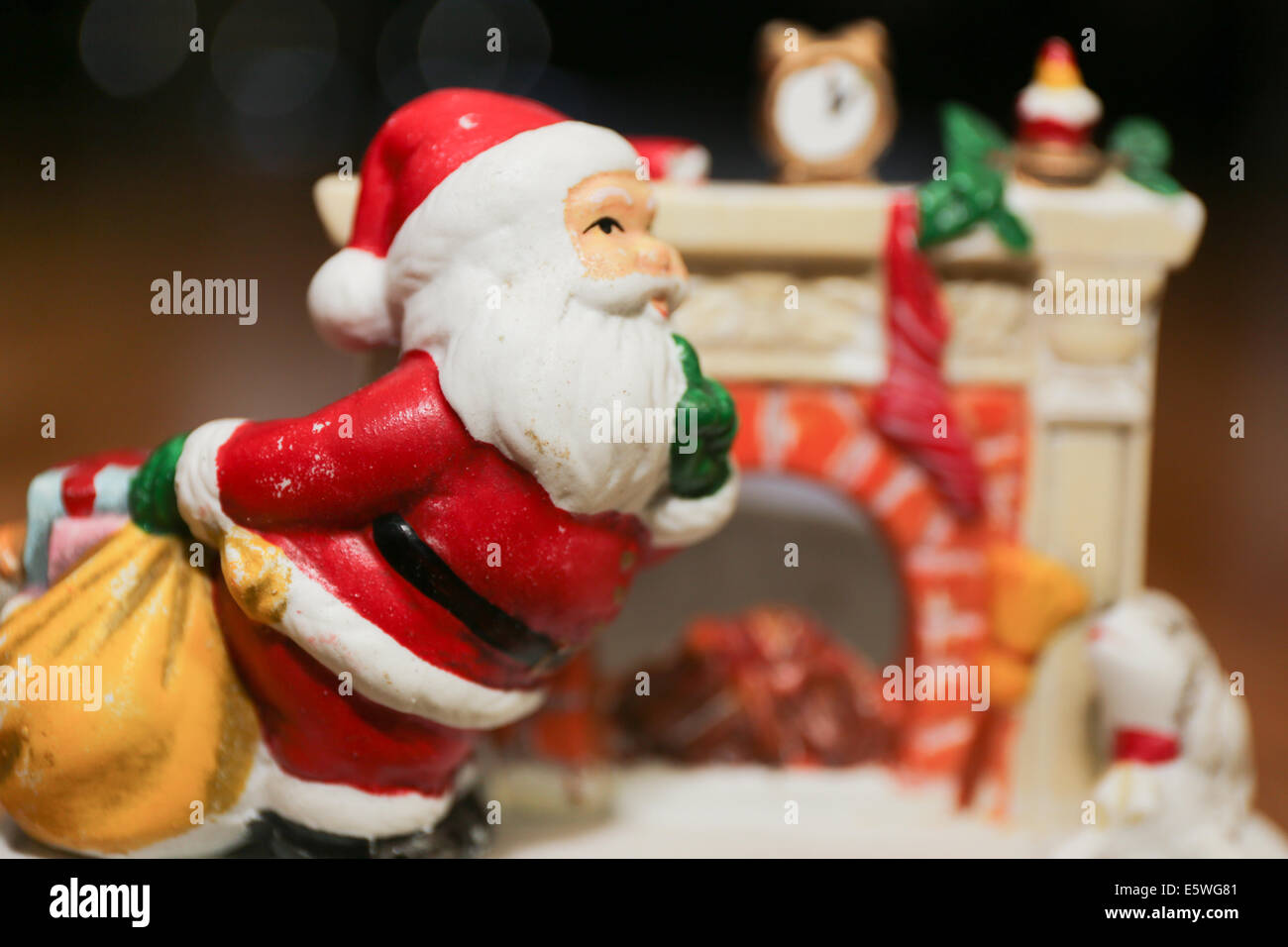 Santa vor einem Kamin liefert Weihnachtsgeschenke Stockfoto