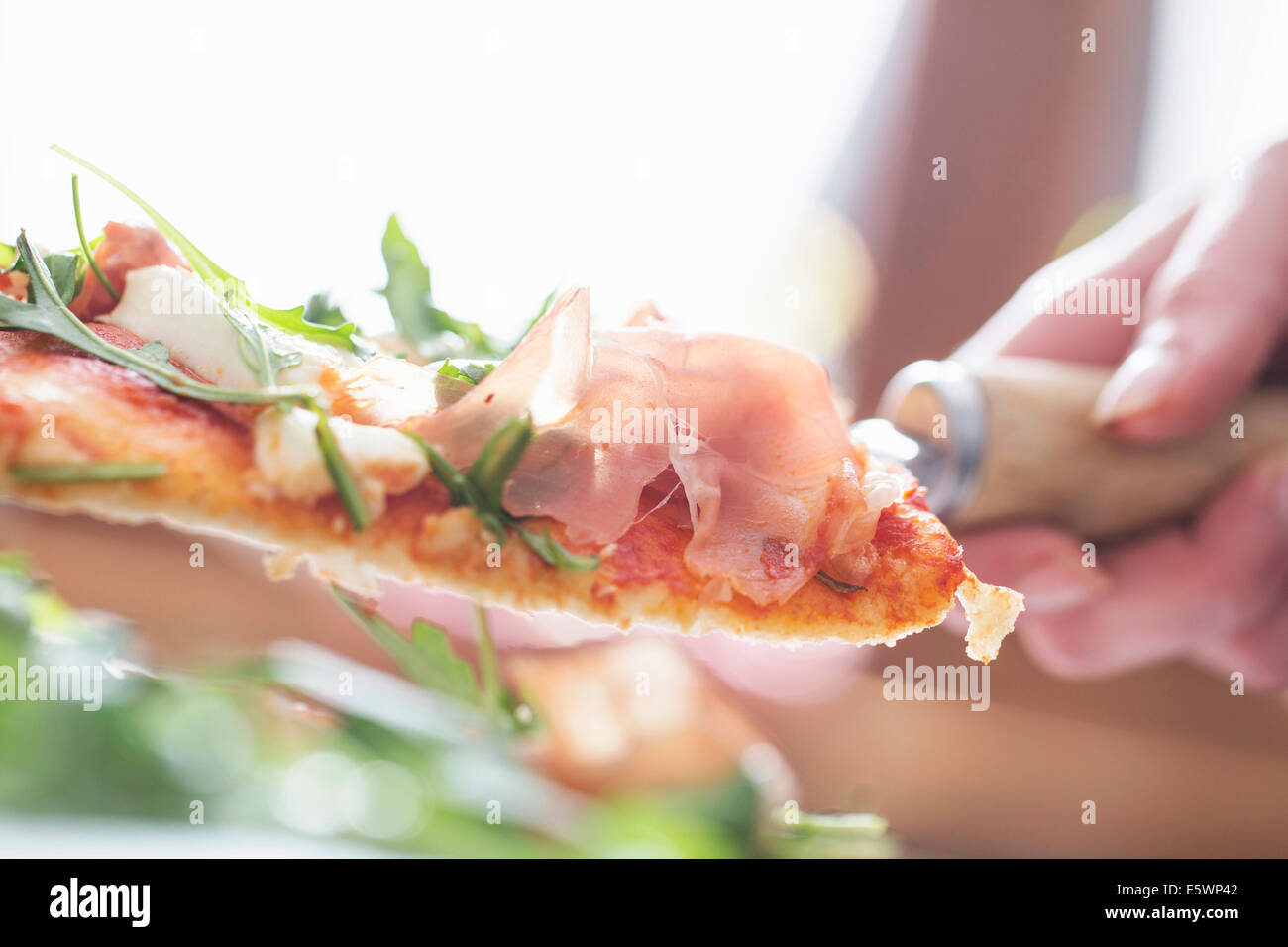 Nahaufnahme von weiblicher Hand mit Pizzastück auf Spachtel abgeschnitten Stockfoto
