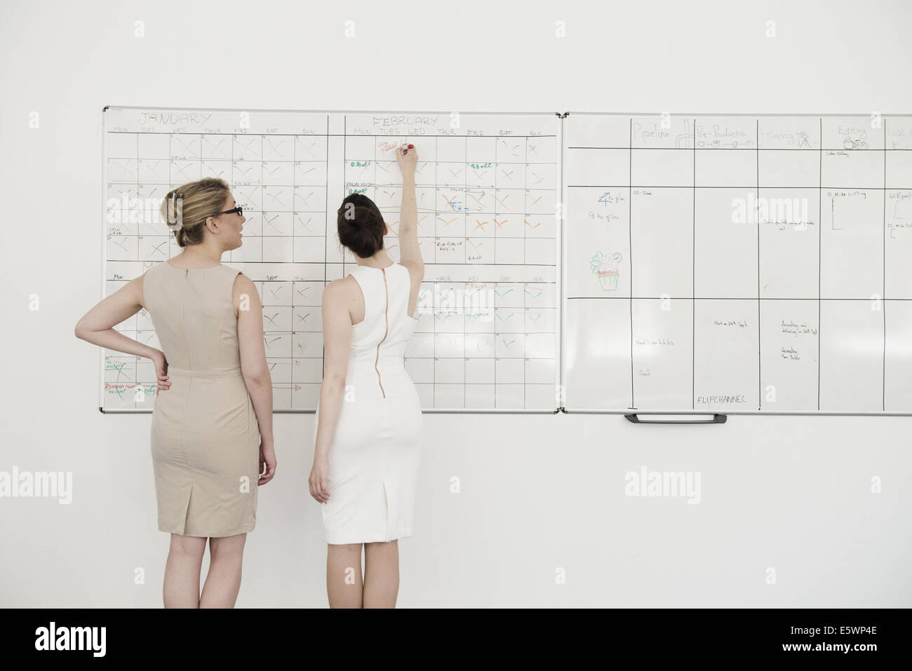Zwei junge Unternehmerinnen Planung auf Büro whiteboard Stockfoto