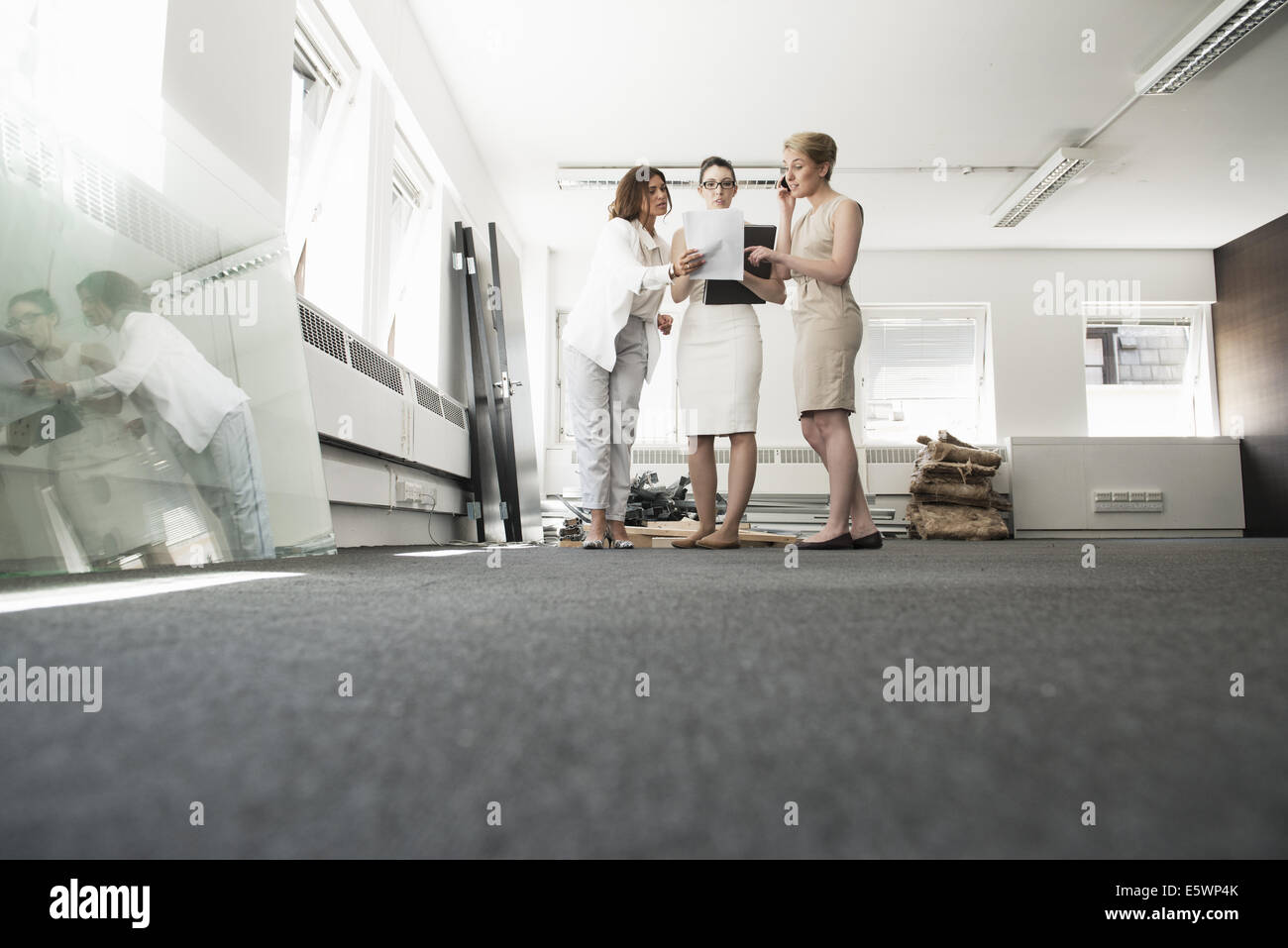 Drei junge Unternehmerinnen im Chat im neuen Büro Stockfoto