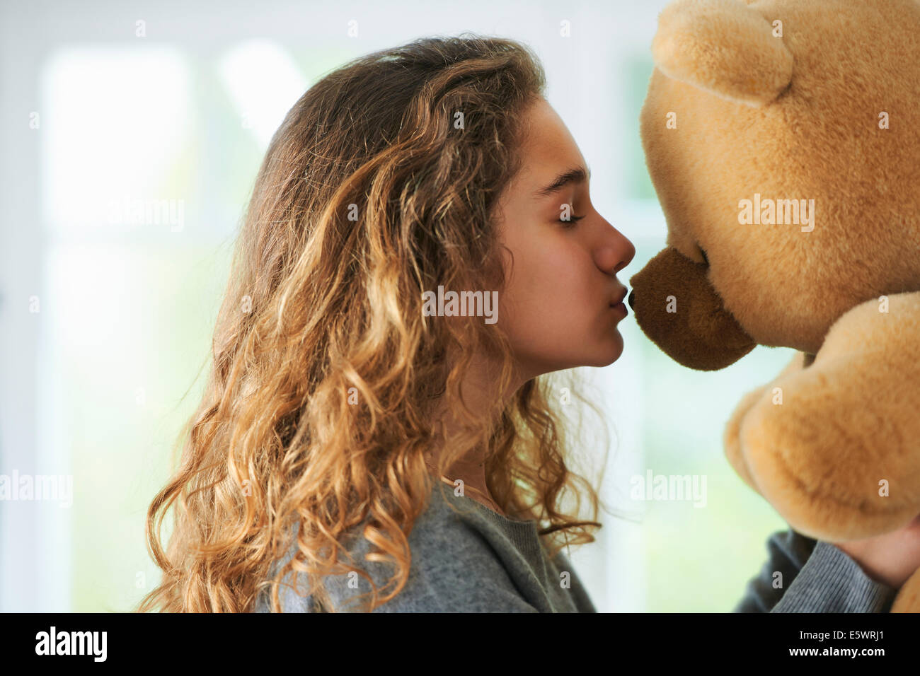 Porträt des jungen Mädchens küssen Teddybär Stockfoto