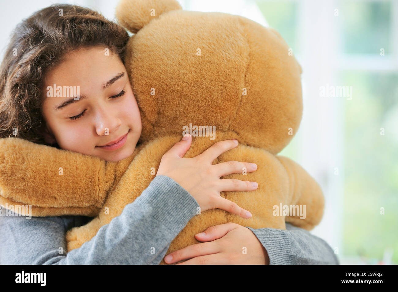 Porträt des jungen Mädchens umarmt Teddybär Stockfoto