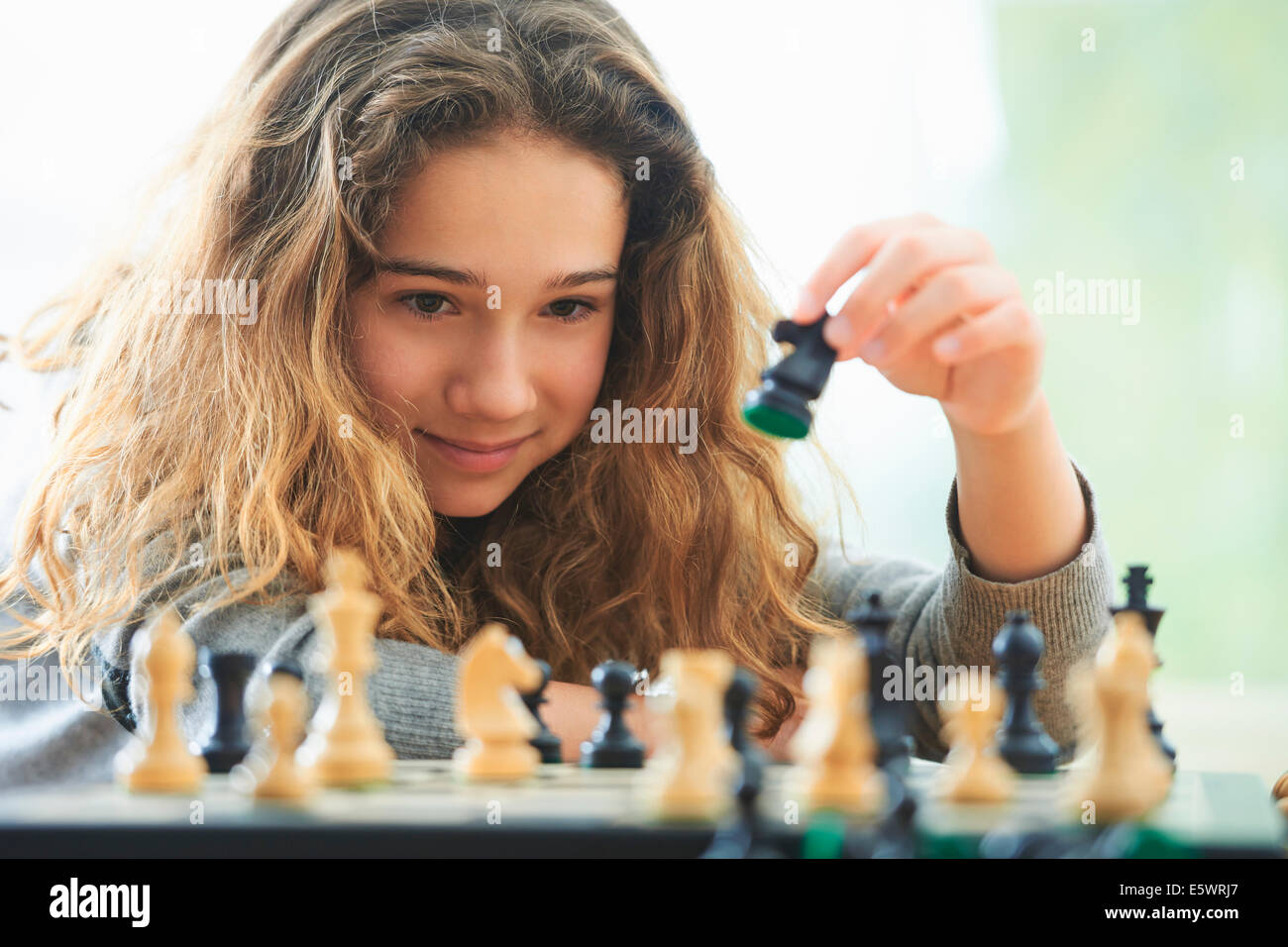 Porträt des jungen Mädchens spielt Schach Stockfoto