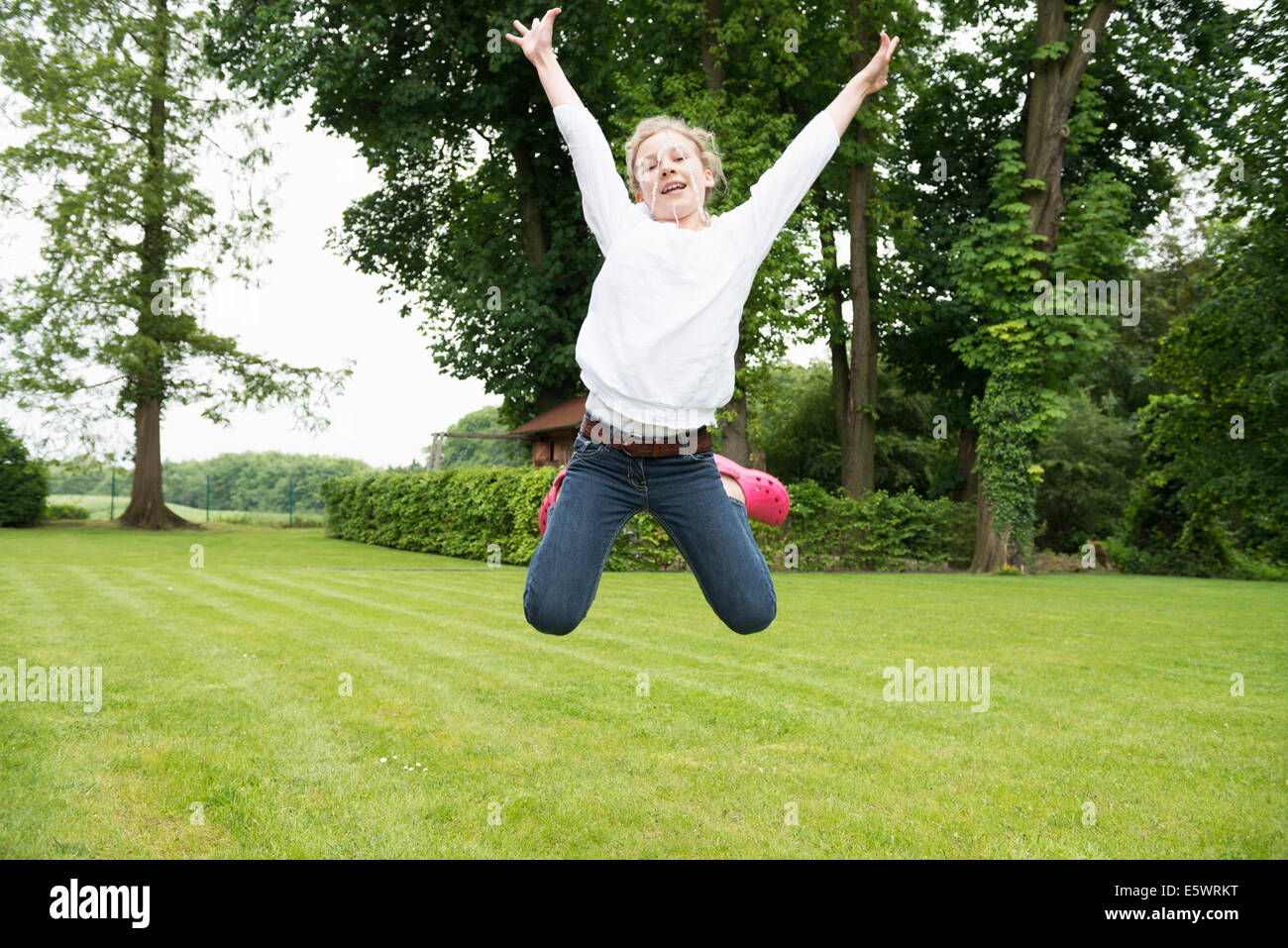 Mädchen im Garten springen Stockfoto