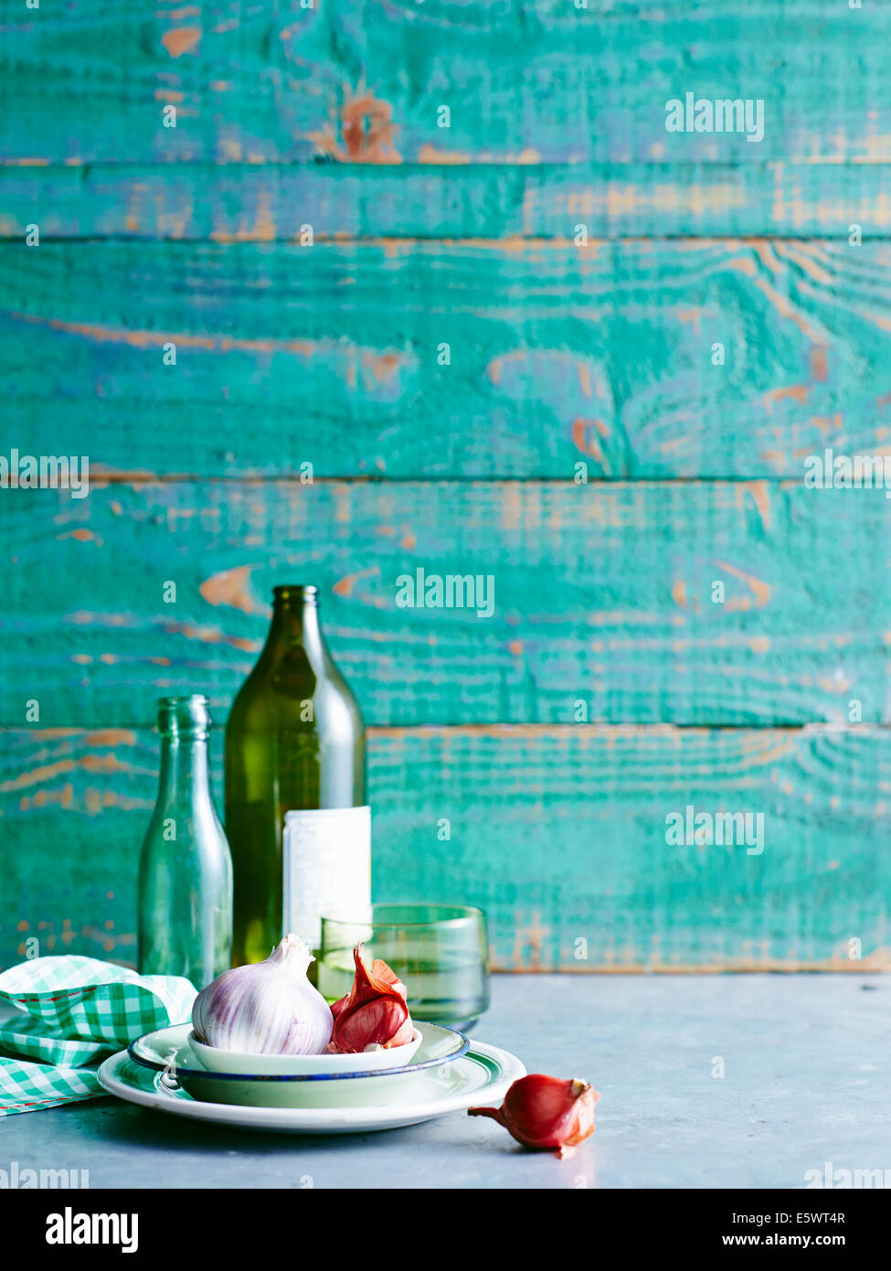 Stillleben mit roten Zwiebeln und Knoblauch Birne mit Flaschen Stockfoto