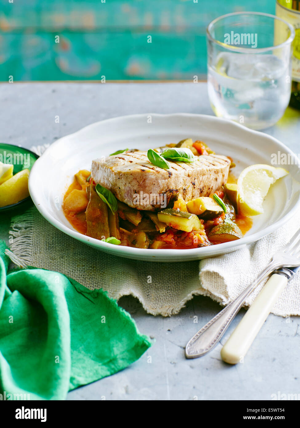 Stillleben-Teller mit Thunfisch, Bohnen und Tomaten-Eintopf mit Zitrone garnieren Stockfoto