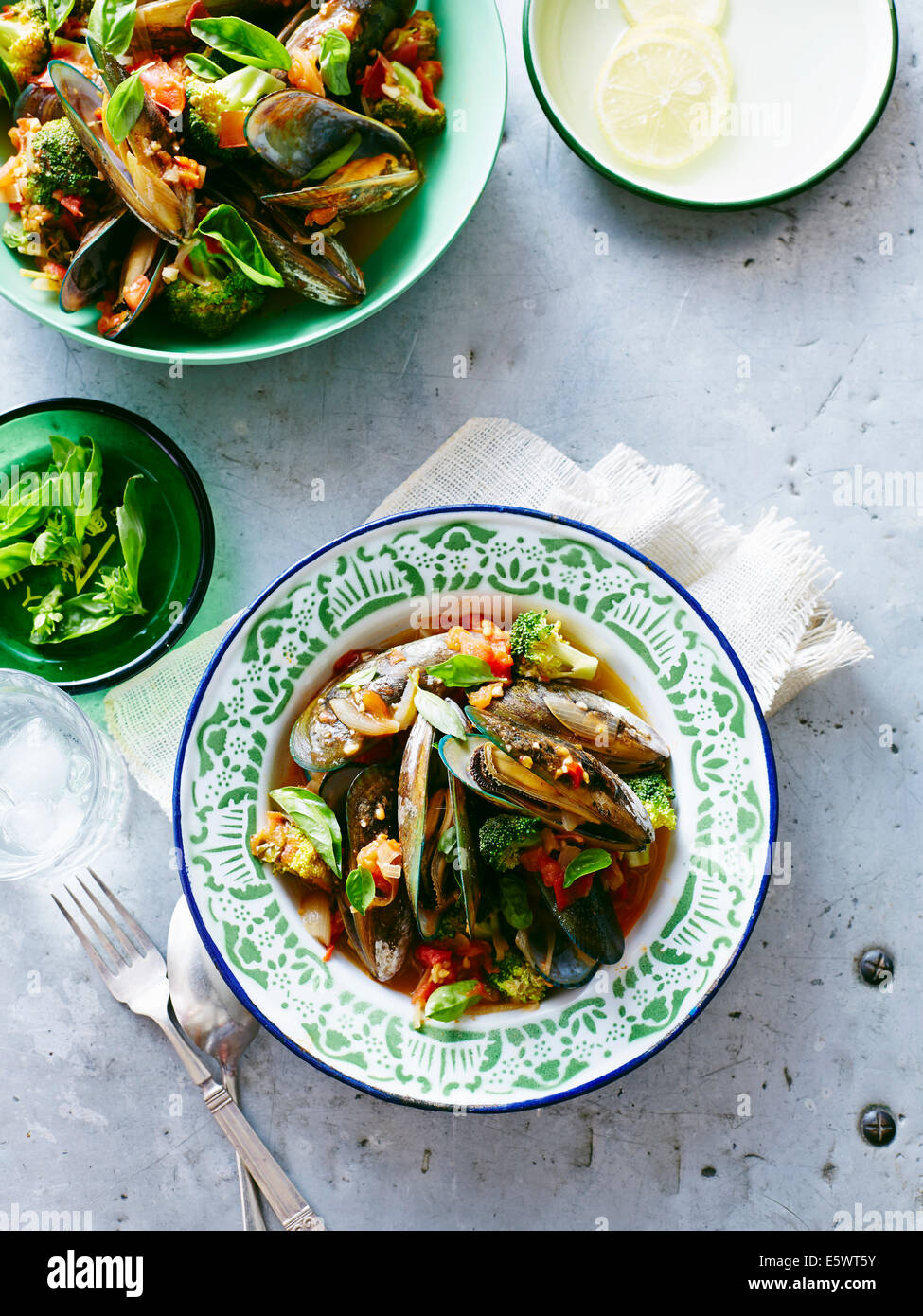 Schalen von Muscheln mit Broccoli in Tomatensauce Stockfoto