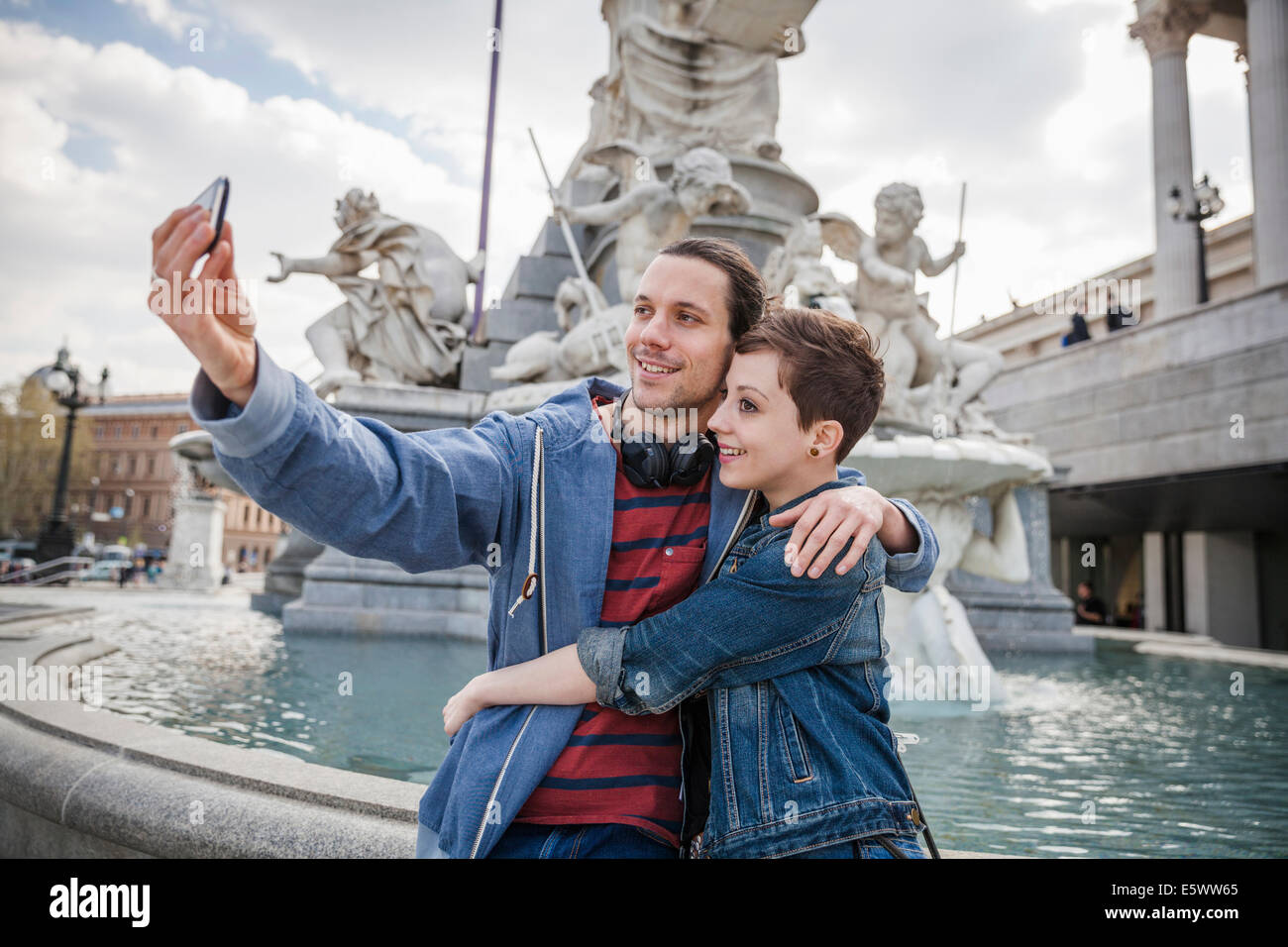 Junge Erwachsene paar unter Bild von sich selbst, Wien, Österreich Stockfoto