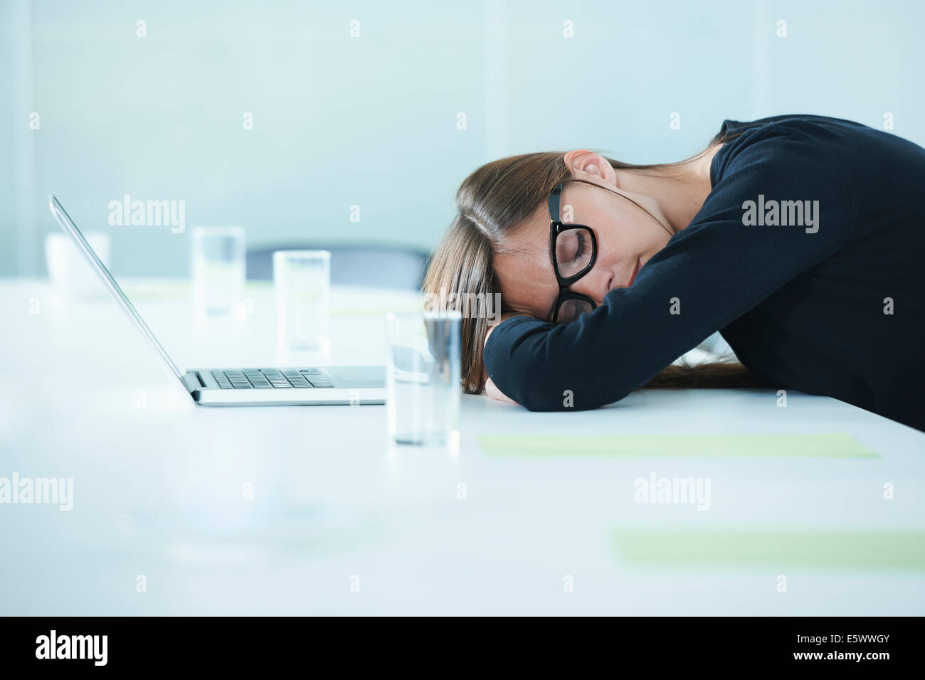 Weibliche Büroangestellte Einschlafen am Konferenztisch Stockfoto
