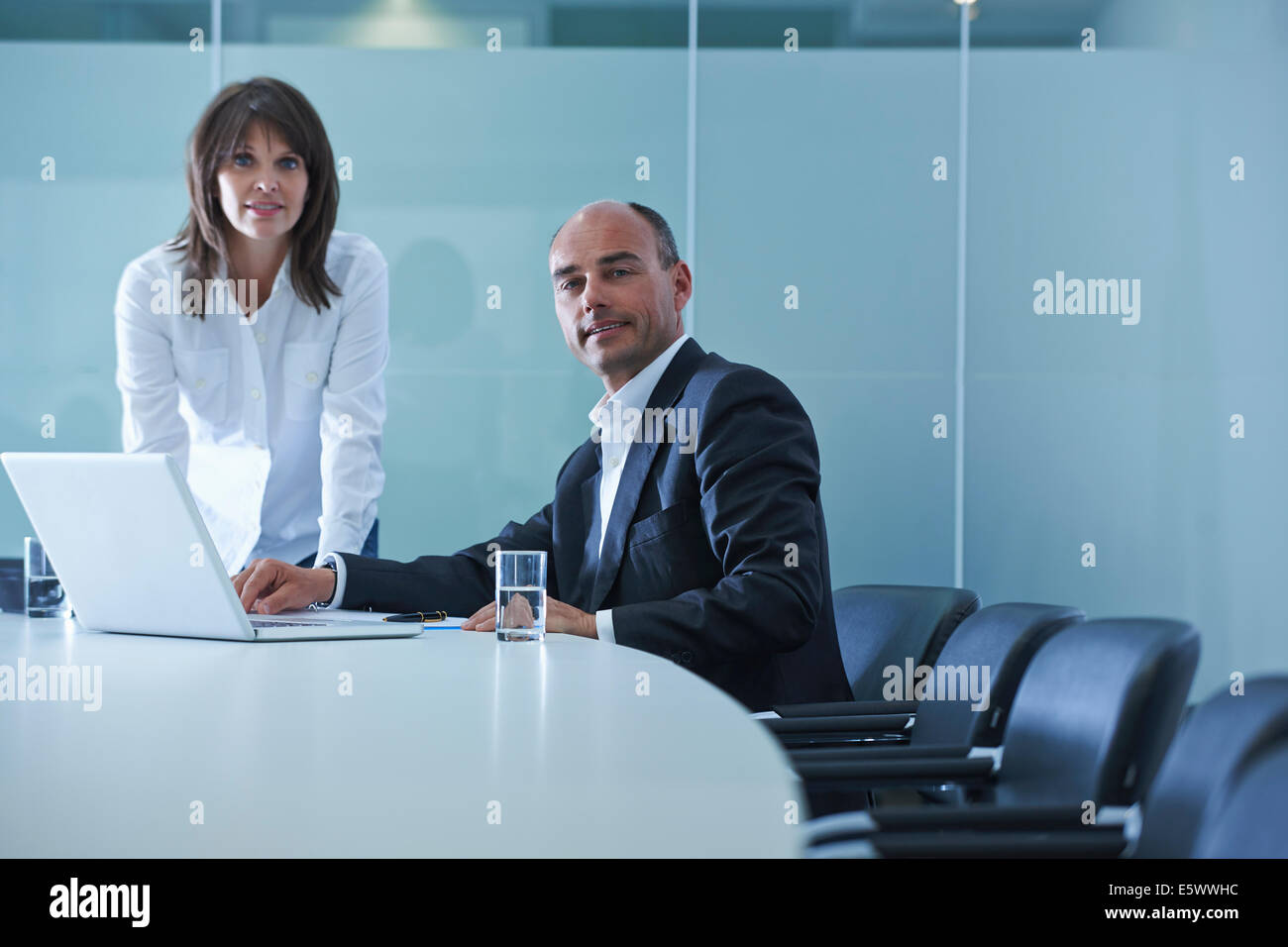 Porträt der Geschäftsfrau und Mann am Konferenztisch Stockfoto