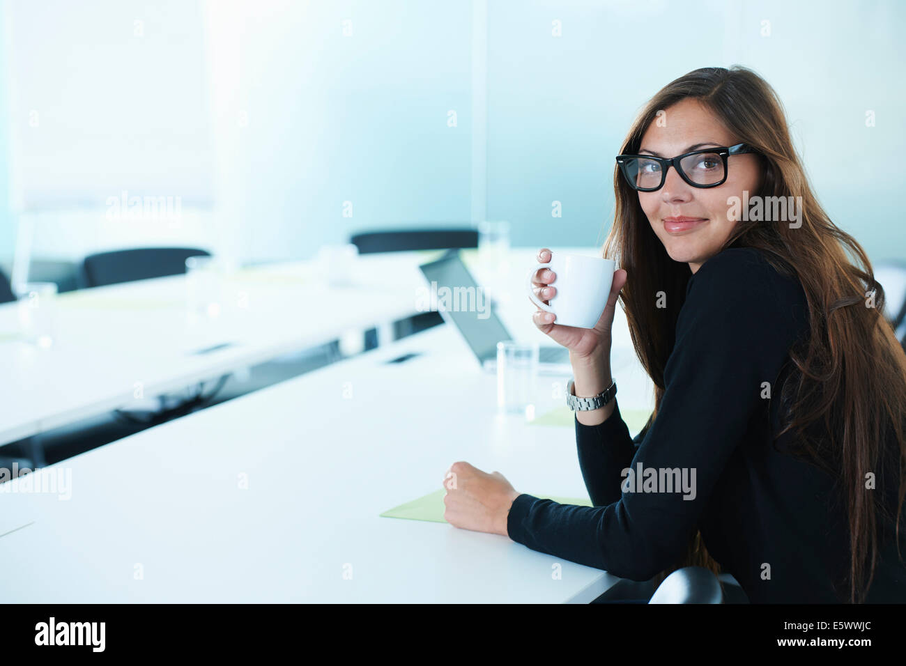 Porträt der Geschäftsfrau Kaffeetrinken am Konferenztisch Stockfoto