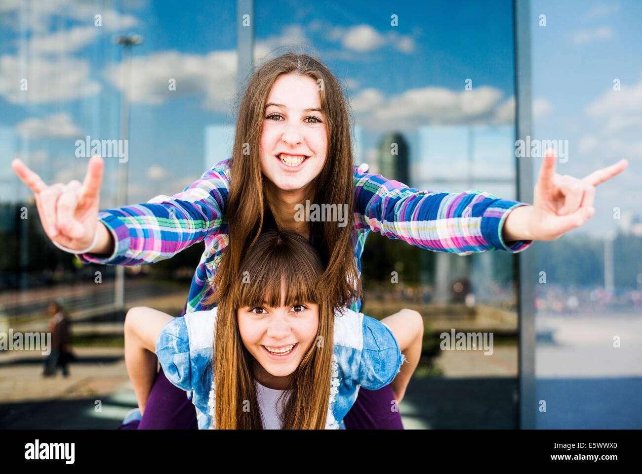 Zwei junge Frauen, Huckepack, so dass ich Sie Liebe Geste der hand Stockfoto