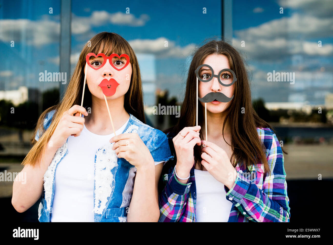 Porträt zweier junger Frauen, Lippen- und Augenpflege Kostüm Masken hochhalten Stockfoto