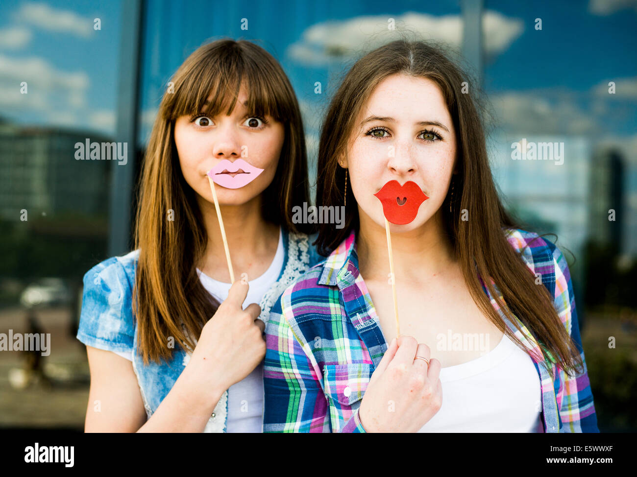 Porträt zweier junger Frauen, die Lippe Kostüm Masken hochhalten Stockfoto