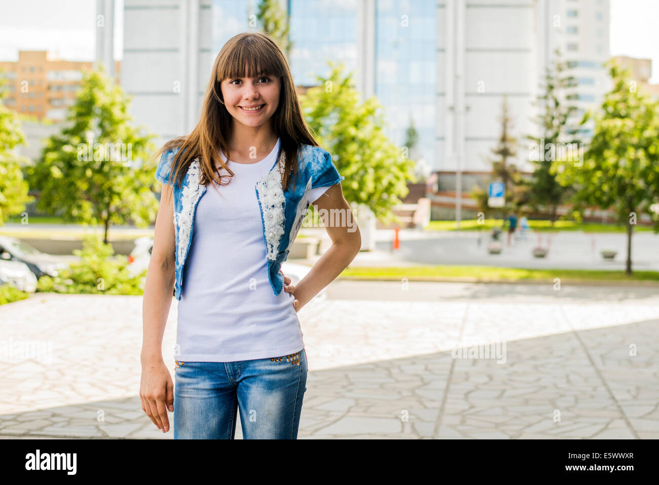 Portrait von junge Frau posiert mit Hand auf die Hüfte in Stadt Stockfoto