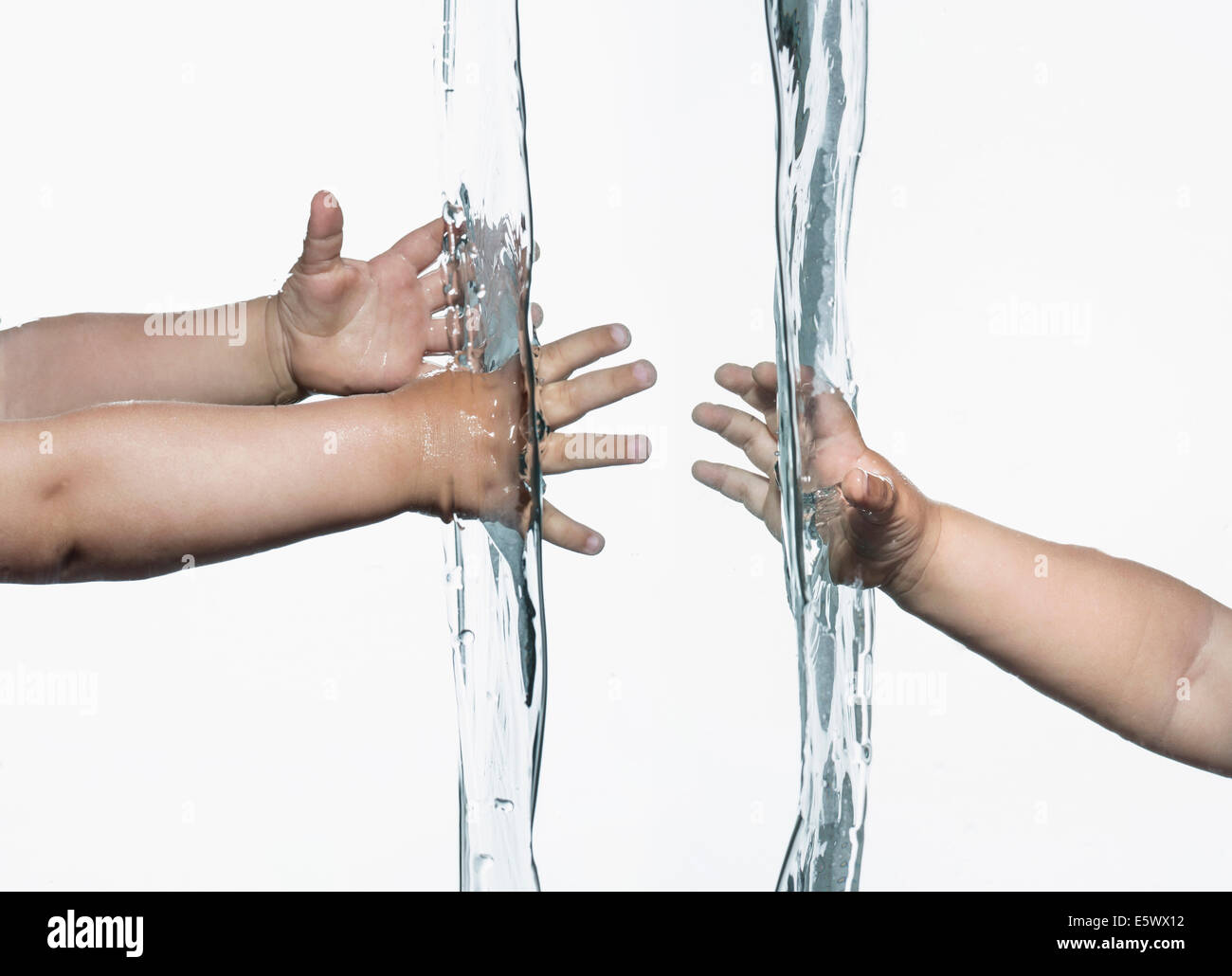 Zusammengesetzte Ansicht der Kleinkinder Arme und Hände ausstrecken von entgegengesetzten Seiten in klarem Wasser Stockfoto