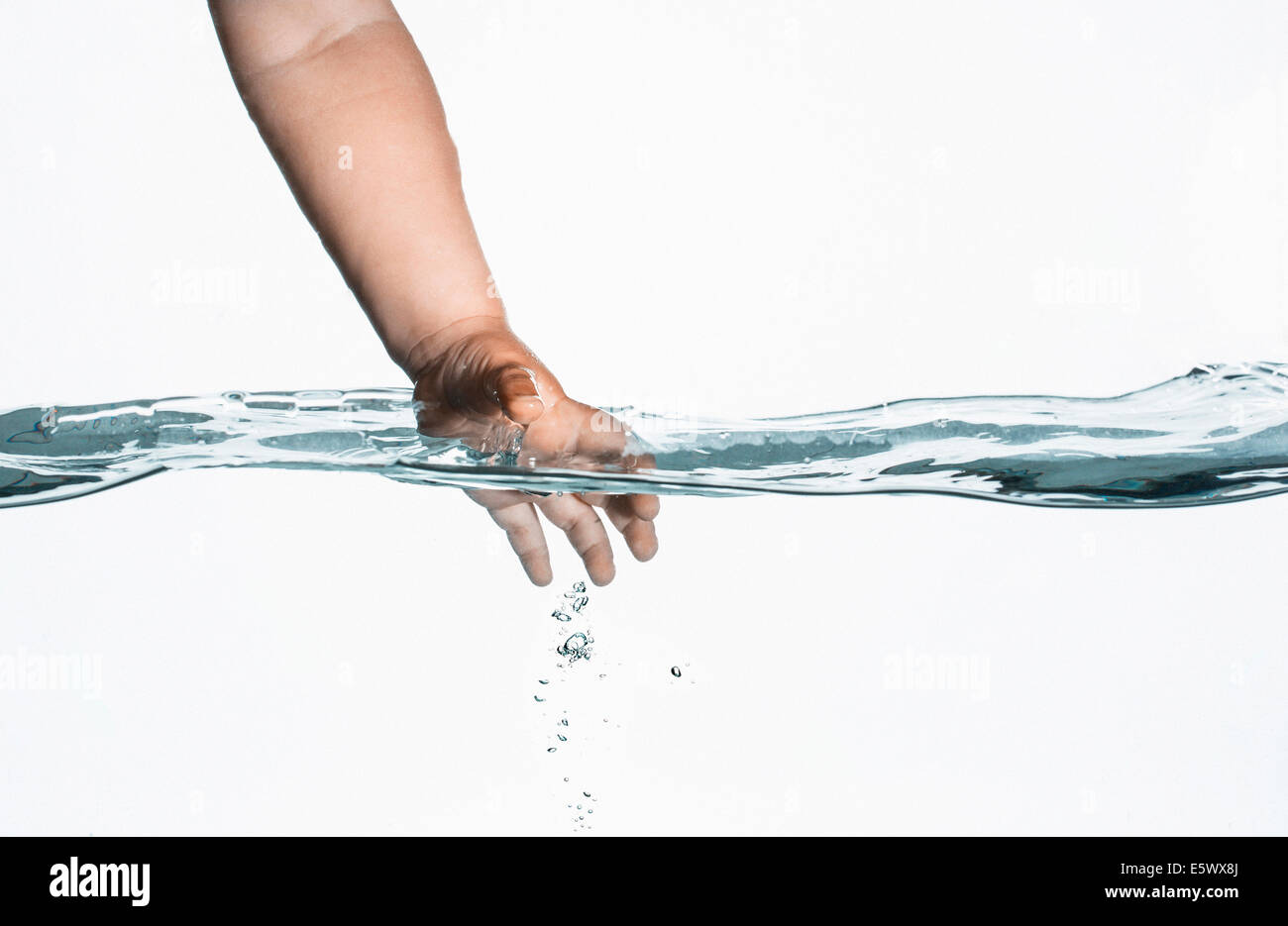 Ebene Oberflächenansicht Kleinkinder Hand Hineingreifen in klarem Wasser Stockfoto