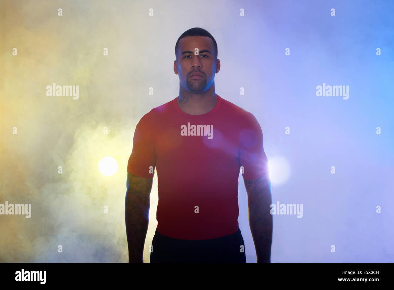 Studio-Porträt der muskulöse junge Sportler in Strahlern und Nebel Stockfoto