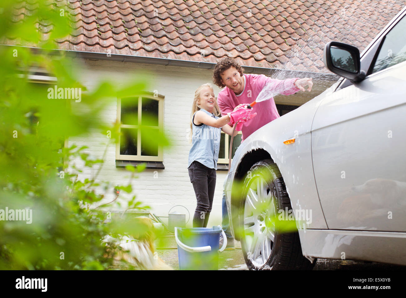 Mädchen half Vater sein Auto waschen Stockfoto