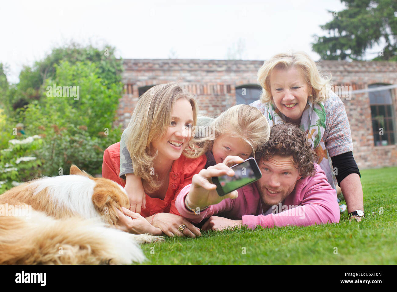 Vater Fotografieren Familie liegen auf Rasen Stockfoto