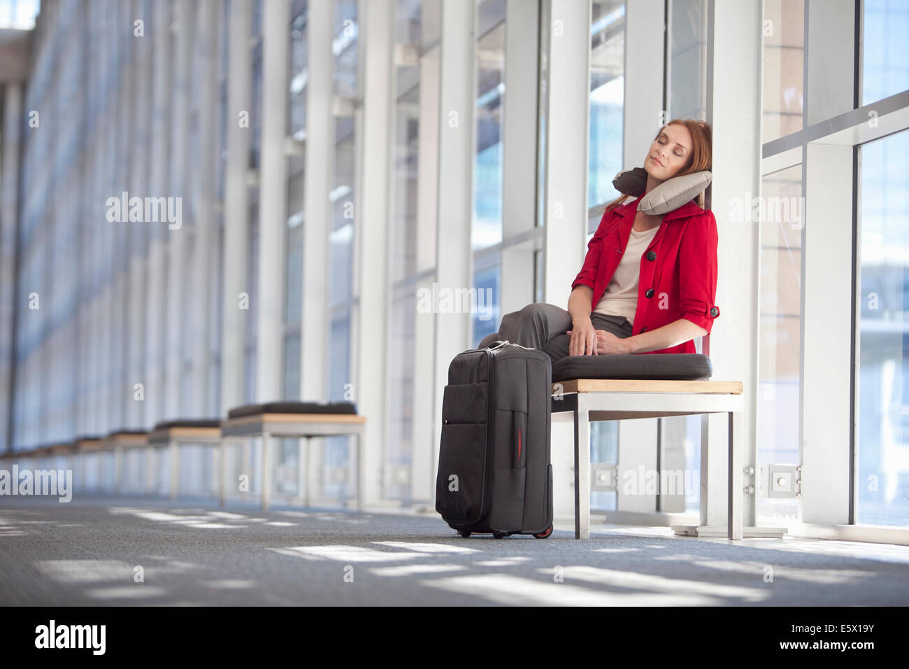 Mitte adult Geschäftsfrau mit Rädern Fall schlafend im Konferenz-Zentrum-Korridor Stockfoto