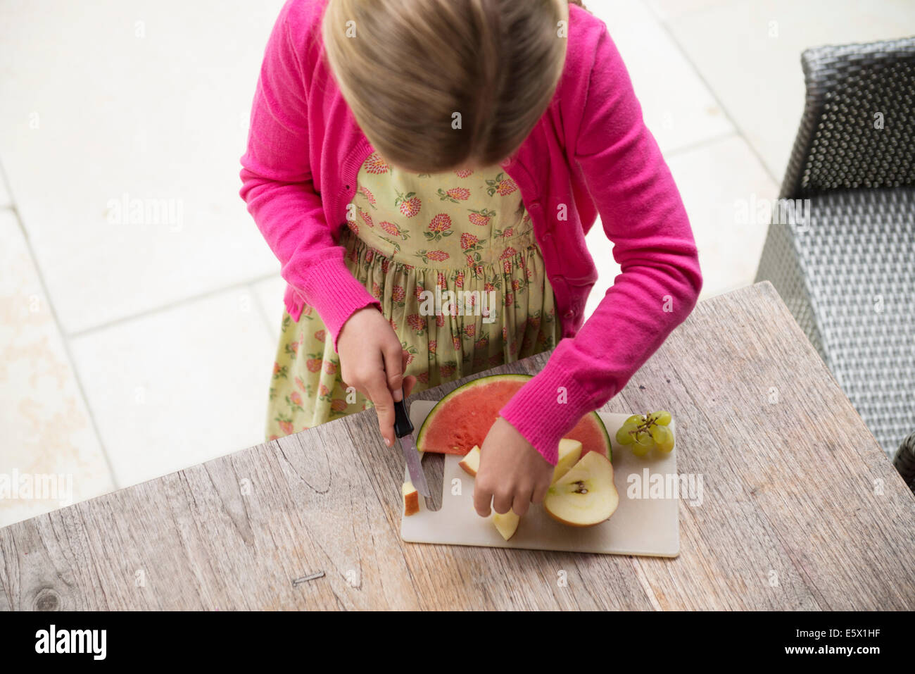 Erhöhte Ansicht des Mädchens am Küchentisch schneiden frisches Obst Stockfoto