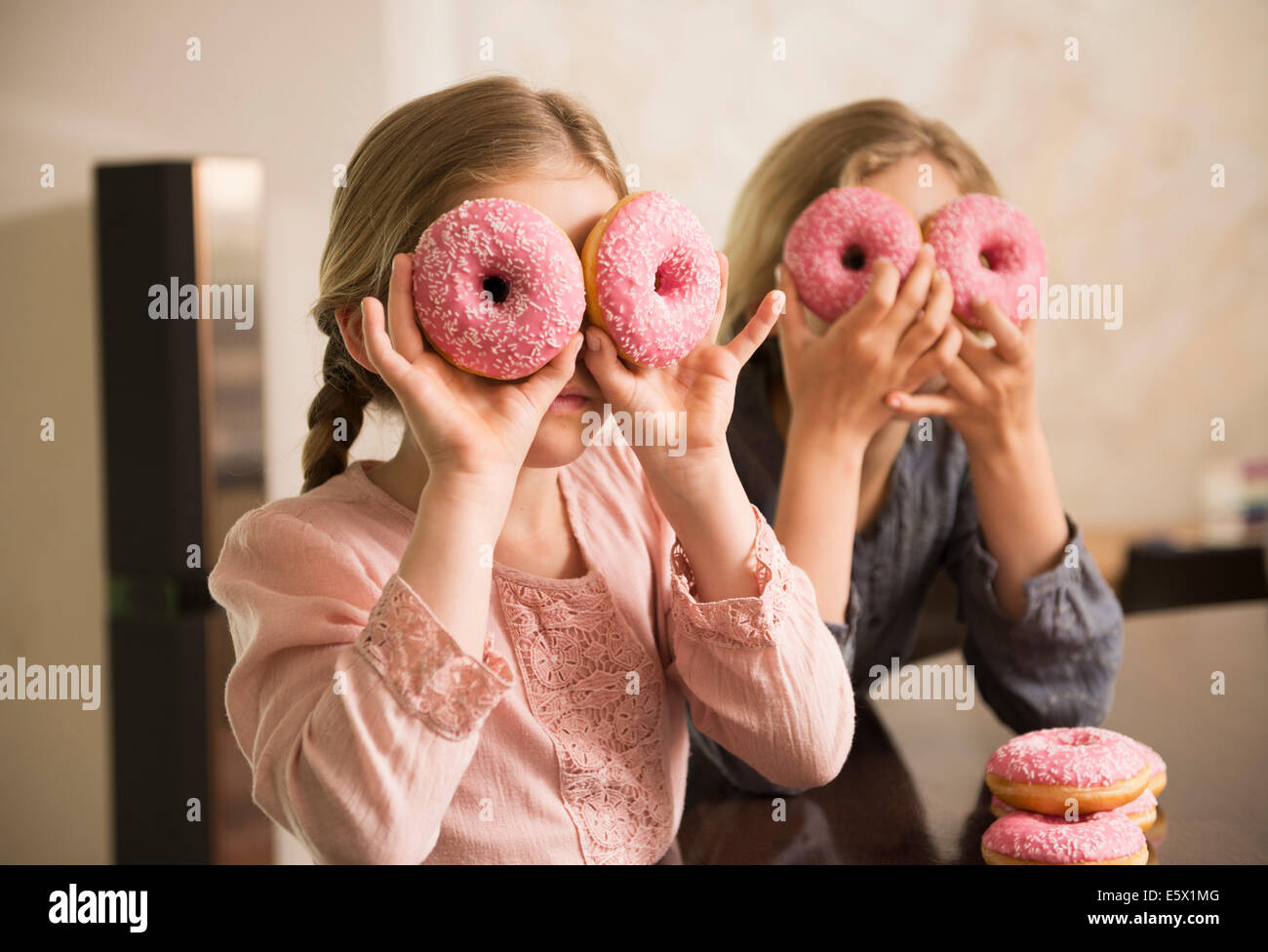 Porträt von zwei Schwestern mit Donut Löcher über den Augen Stockfoto