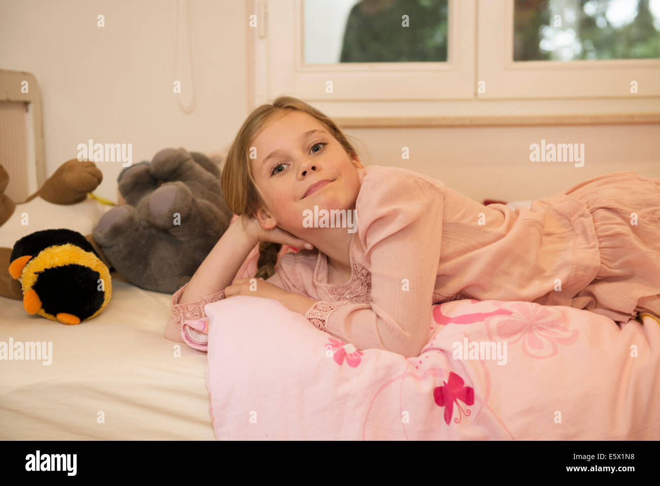 Porträt des schelmischen Mädchen auf Bett liegend Stockfoto