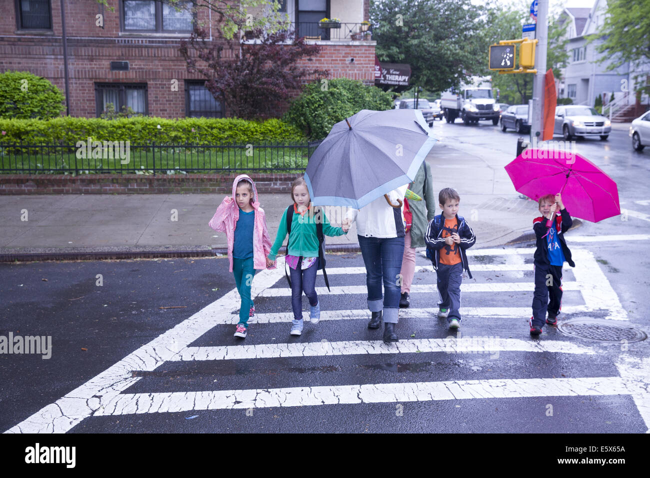 Kinder nach Hause gehen nach der Schule an einem regnerischen Tag in Brooklyn, New York. Stockfoto