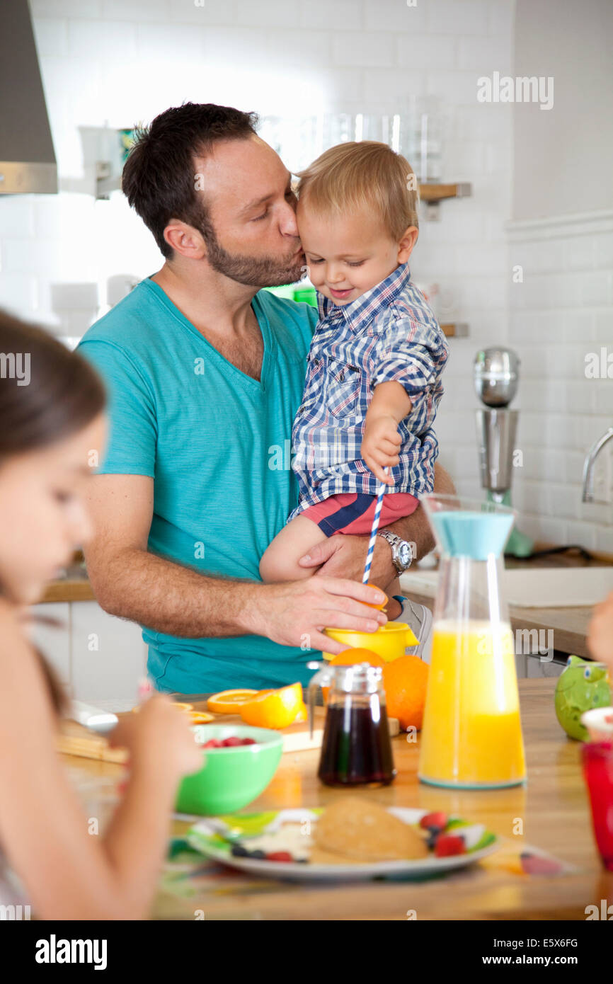 Mitte erwachsener Mann-Multitasking-Frühstück mit Sohn und Tochter Stockfoto