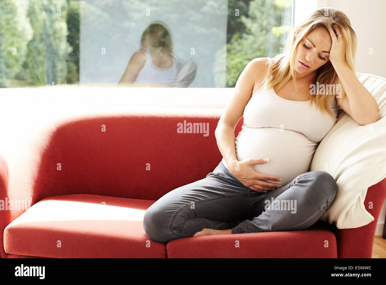 Schwangere Frau saß allein Stockfoto