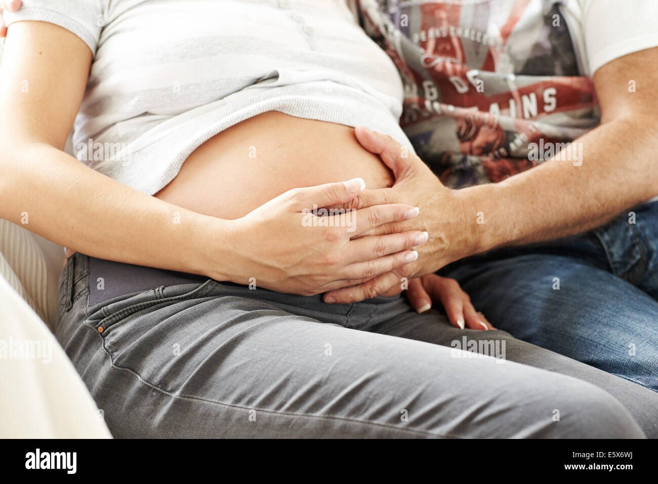 Schwangere Frau saß mit partner Stockfoto