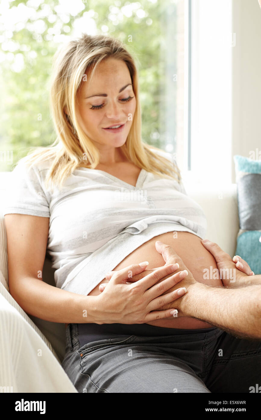 Schwangere Frau saß mit partner Stockfoto
