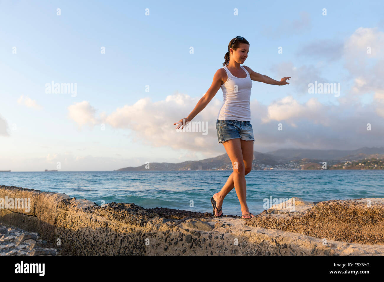 Mitte Erwachsene Frau zu Fuß entlang der Pier, Spice Island Beach Resort, Grenada, Caribbean Stockfoto