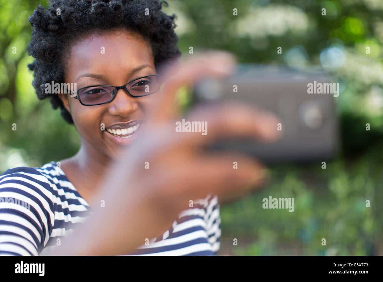 Junge Frau im Park unter Selfie auf Digitalkamera Stockfoto