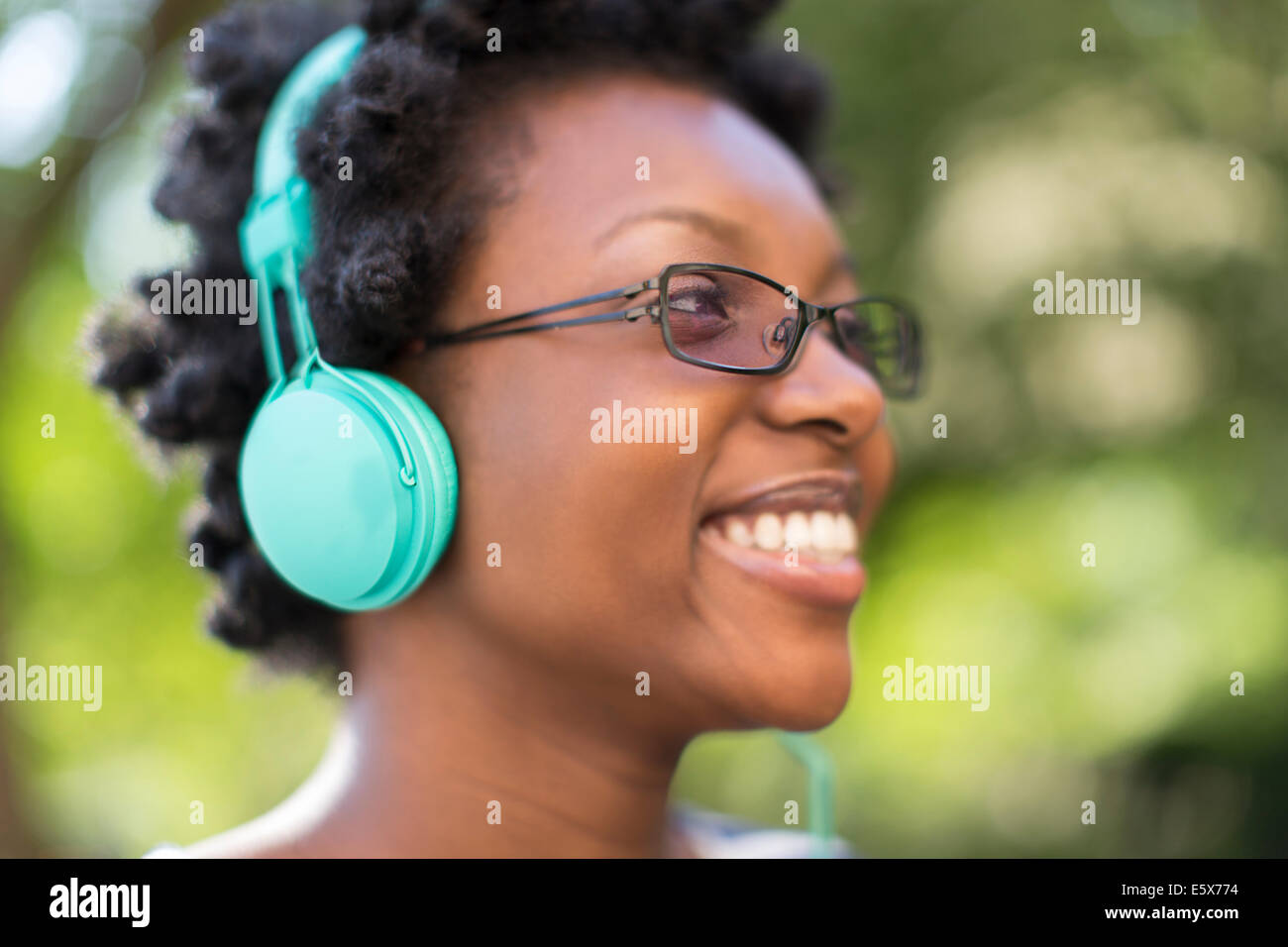 Nahaufnahme von junge Frau im Park Kopfhörer anhören Stockfoto