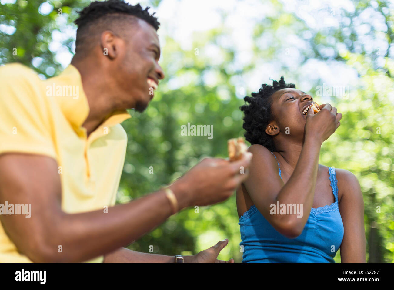 Junges Paar im Park Essen sandwiches Stockfoto