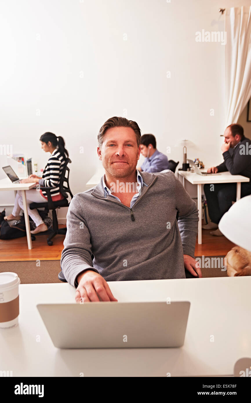 Portrait von Mann mit Laptop im Amt Stockfoto