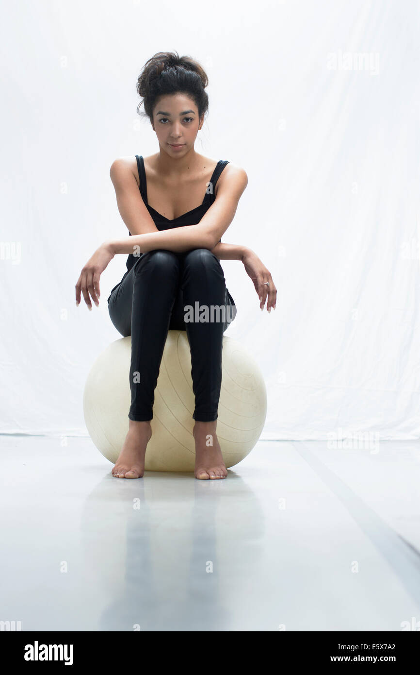 Studio-Porträt der selbstbewusste junge Frau sitzen auf Gymnastikball Stockfoto