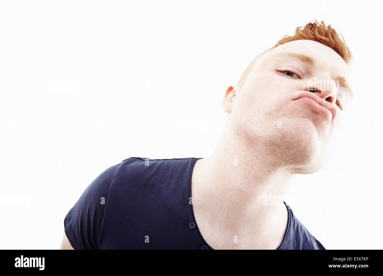 Studio-Porträt des jungen Mannes zieht ein Gesicht Stockfoto