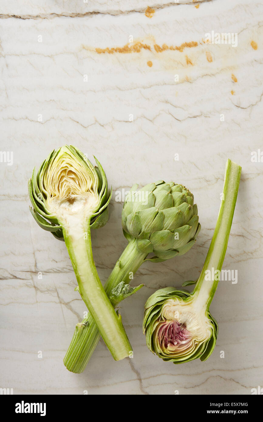 Drei frisch geschnittene Artischocken auf Marmor Oberfläche Stockfoto