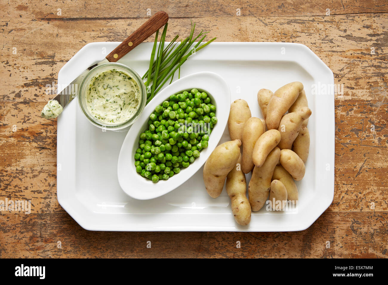 Fingerling Kartoffeln und Erbsen Frühling mit einem Schnittlauch zusammengesetzte Butter serviert Stockfoto
