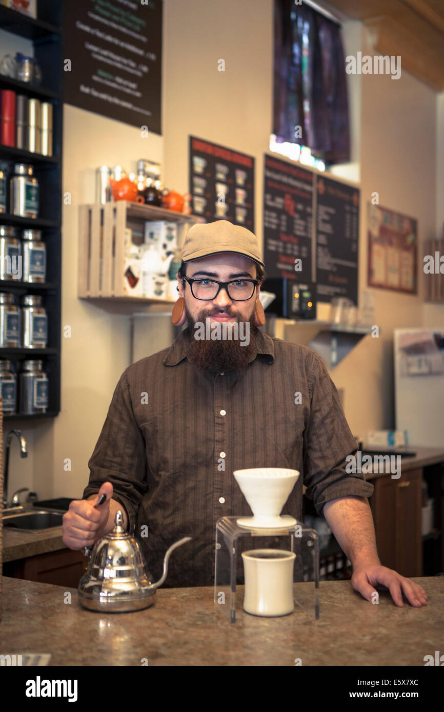 Porträt von Barista serviert Tee an Café-Zähler Stockfoto