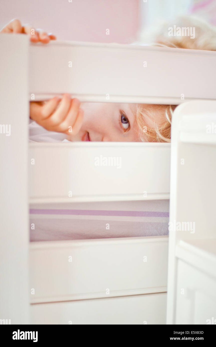 Porträt von vier Jahre alten Jungen durch Bettgestell peeking hautnah Stockfoto